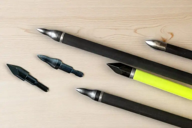 carbonpfeil pfeilspitzen unetrschiedlicher art vor einem holzhintergrund